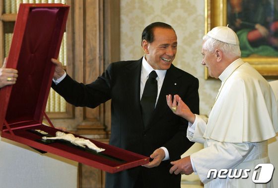 실비오 베를루스코니 전 이탈리아 총리가 지난 2005년 11월19일(현지시간) 바티칸에서 당시 교황인 베네딕토 16세에게 십자가를 선물하고 있다. © AFP=뉴스1 © News1 김민수 기자