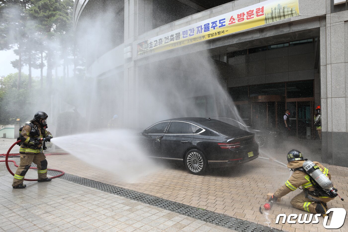 본문 이미지 - 14일 오후 서울 강남구 도곡동의 한 초고층 아파트에서 열린 전기차 화재를 가정한 민·관 합동 소방훈련에서 소방대원들이 전기차 화재를 진압하고 있다.  2023.6.14/뉴스1 ⓒ News1 신웅수 기자