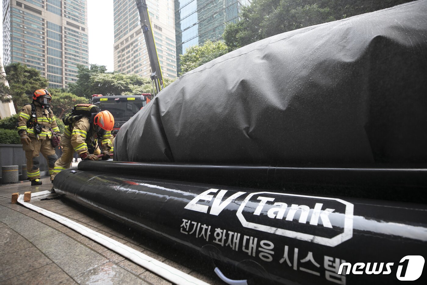 본문 이미지 - 14일 오후 서울 강남구 도곡동의 한 초고층 아파트에서 열린 전기차 화재를 가정한 민·관 합동 소방훈련에서 소방대원들이 전기차 화재대응 시스템을 가동하고 있다. 2023.6.14/뉴스1 ⓒ News1 신웅수 기자