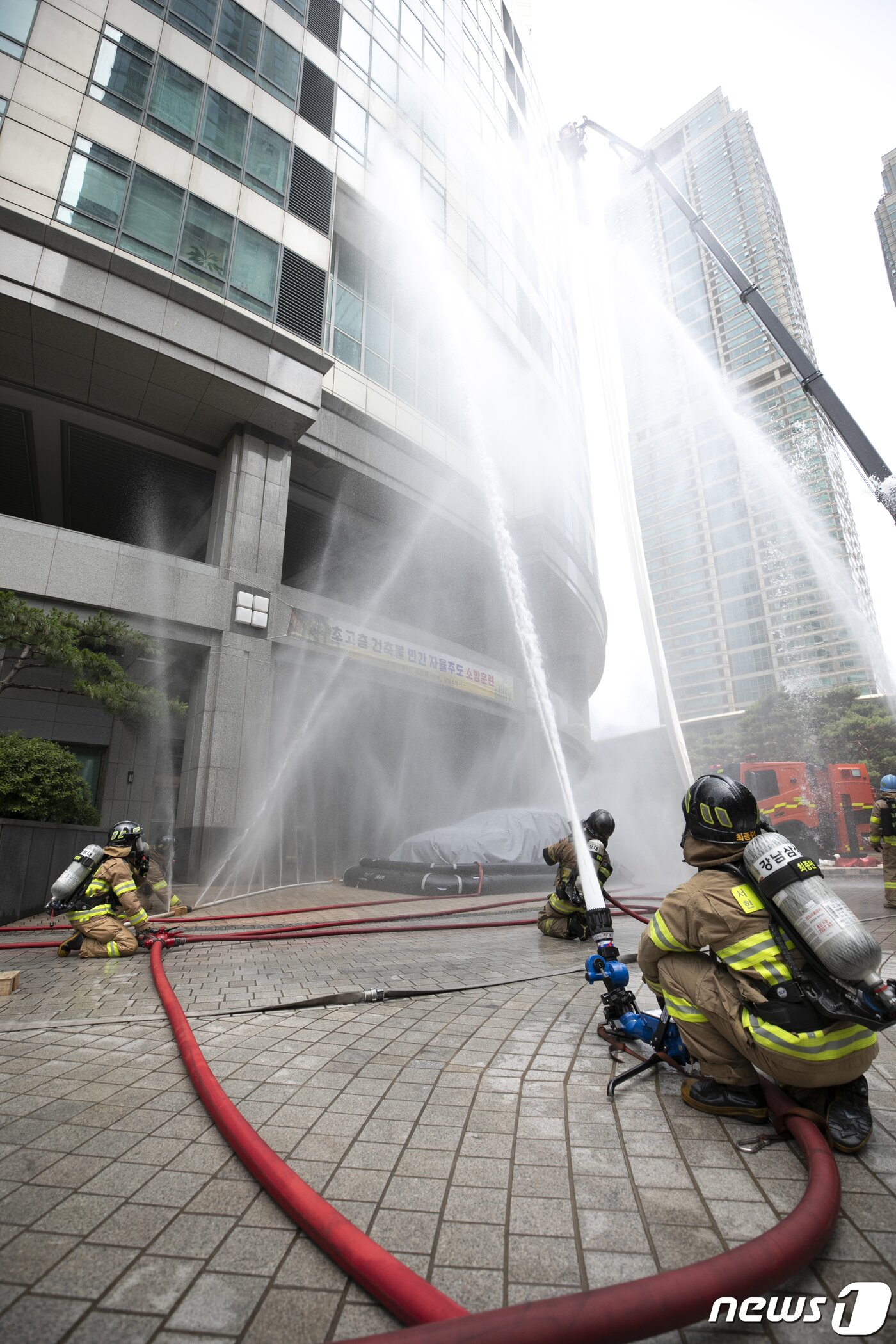 본문 이미지 - 14일 오후 서울 강남구 도곡동의 한 초고층 아파트에서 열린 전기차 화재를 가정한 민·관 합동 소방훈련에서 소방대원들이 화재를 진압하고 있다. 2023.6.14/뉴스1 ⓒ News1 신웅수 기자