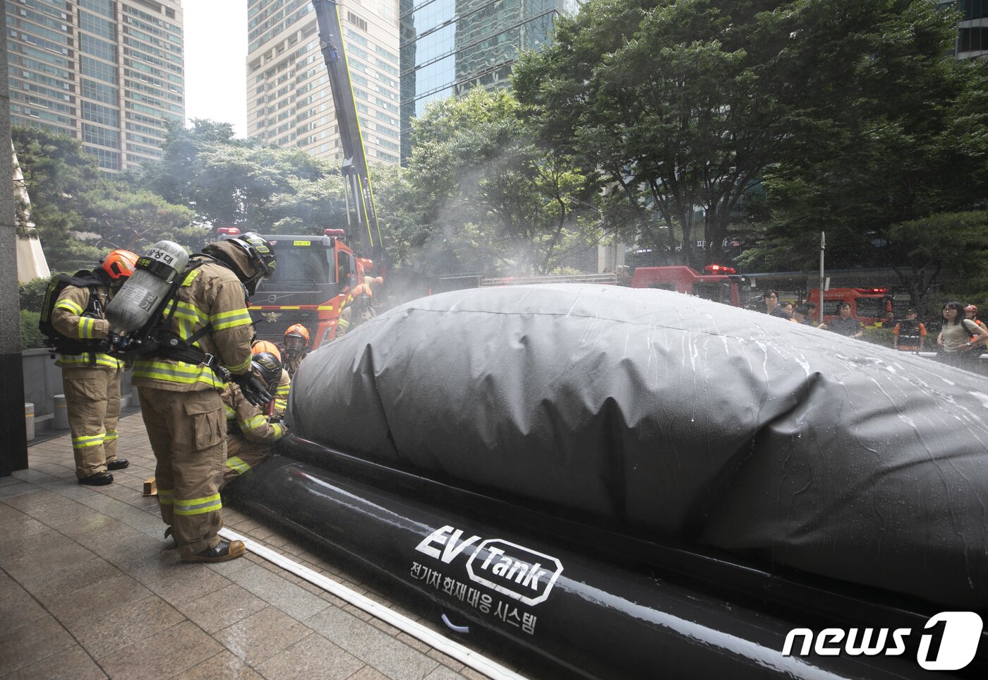 본문 이미지 - 14일 오후 서울 강남구 도곡동의 한 초고층 아파트에서 열린 전기차 화재를 가정한 민·관 합동 소방훈련에서 소방대원들이 전기차 화재를 진압하고 있다.  2023.6.14/뉴스1 ⓒ News1 신웅수 기자