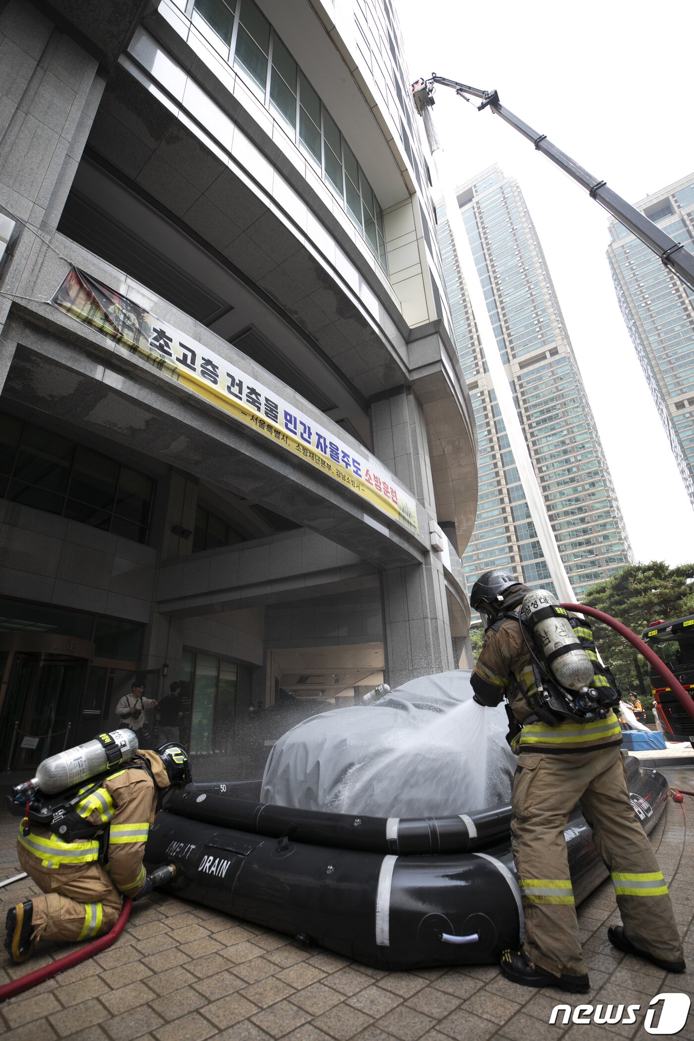 본문 이미지 - 14일 오후 서울 강남구 도곡동의 한 초고층 아파트에서 열린 전기차 화재를 가정한 민·관 합동 소방훈련에서 소방대원들이 화재를 진압하고 있다.  2023.6.14/뉴스1 ⓒ News1 신웅수 기자