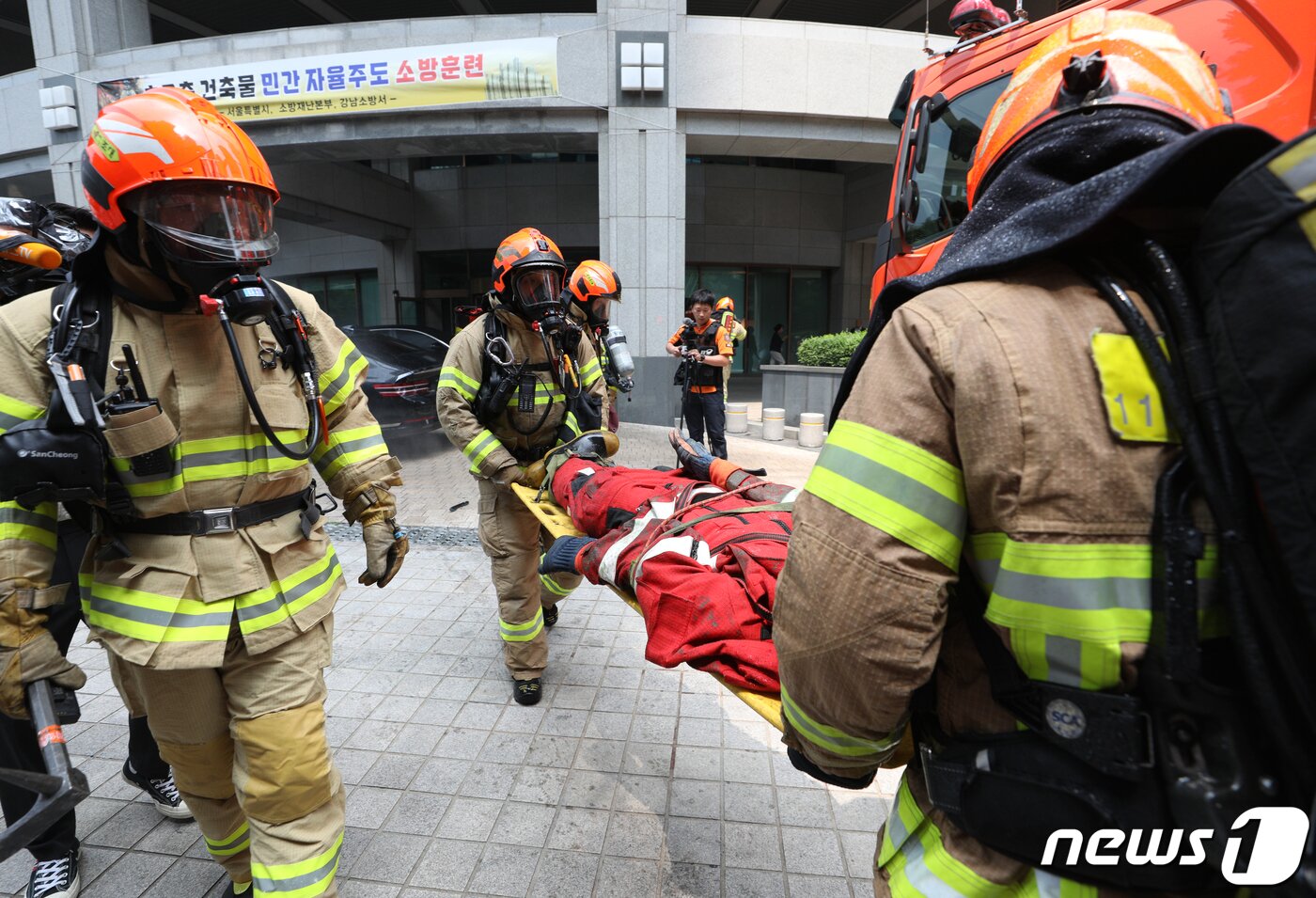 본문 이미지 - 14일 오후 서울 강남구 도곡동의 한 초고층 아파트에서 열린 전기차 화재를 가정한 민·관 합동 소방훈련에서 소방대원들이 전기차 차량 탑승자를 구조하고 있다. 2023.6.14/뉴스1 ⓒ News1 신웅수 기자