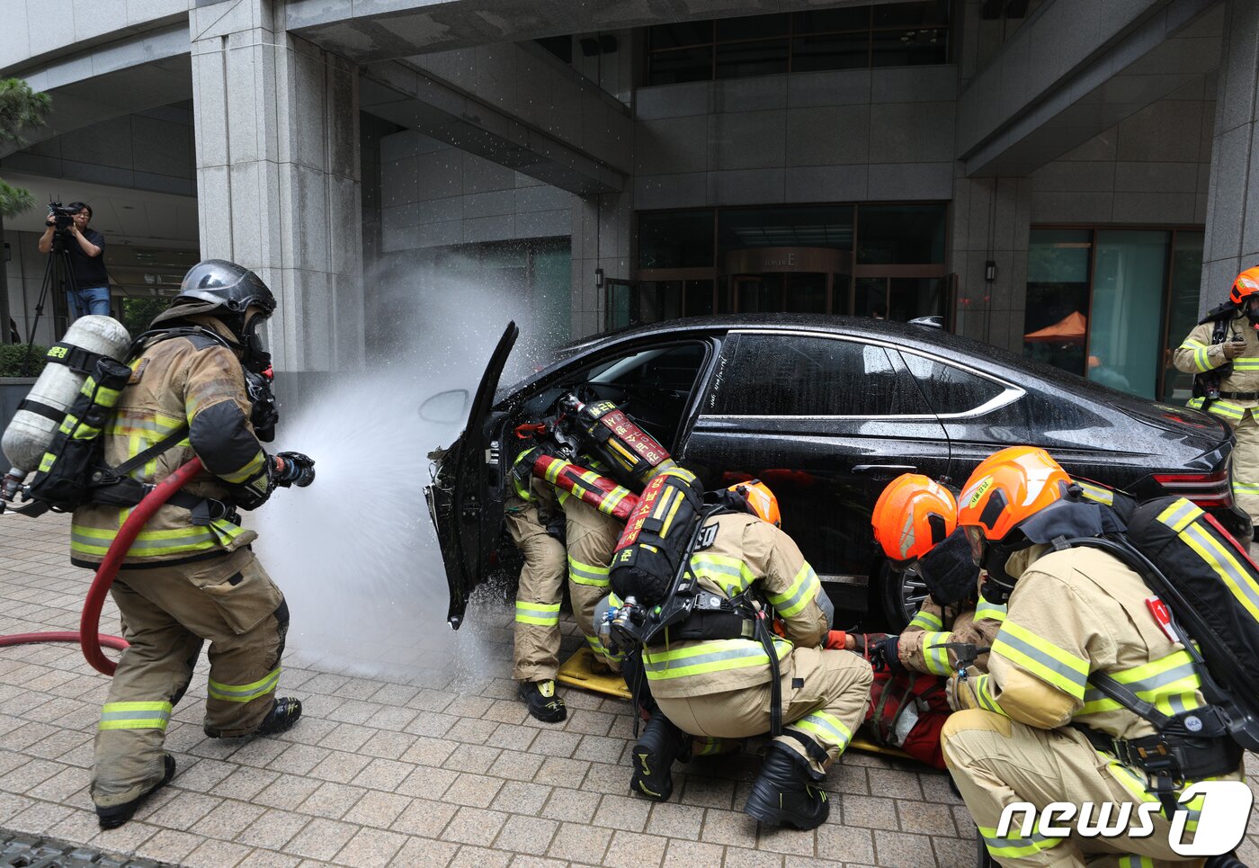 본문 이미지 - 14일 오후 서울 강남구 도곡동의 한 초고층 아파트에서 열린 전기차 화재를 가정한 민·관 합동 소방훈련에서 소방대원들이 전기차 화재를 진압하고 있다.  2023.6.14/뉴스1 ⓒ News1 신웅수 기자