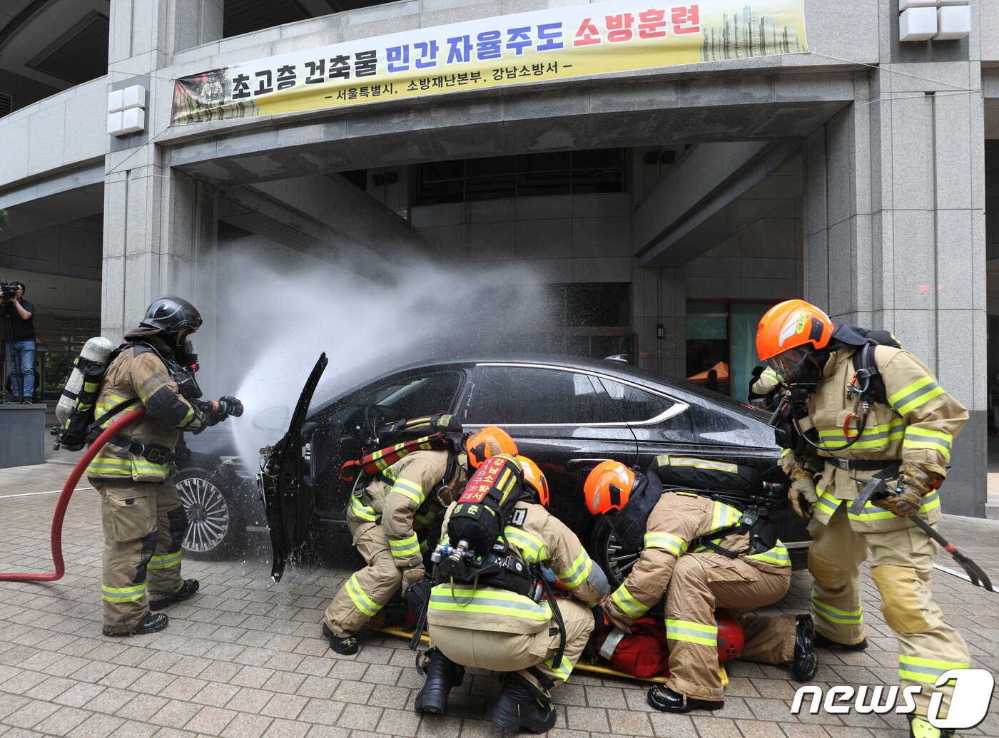 본문 이미지 - 14일 오후 서울 강남구 도곡동의 한 초고층 아파트에서 열린 전기차 화재를 가정한 민·관 합동 소방훈련에서 소방대원들이 전기차 화재를 진압하고 있다.  2023.6.14/뉴스1 ⓒ News1 신웅수 기자