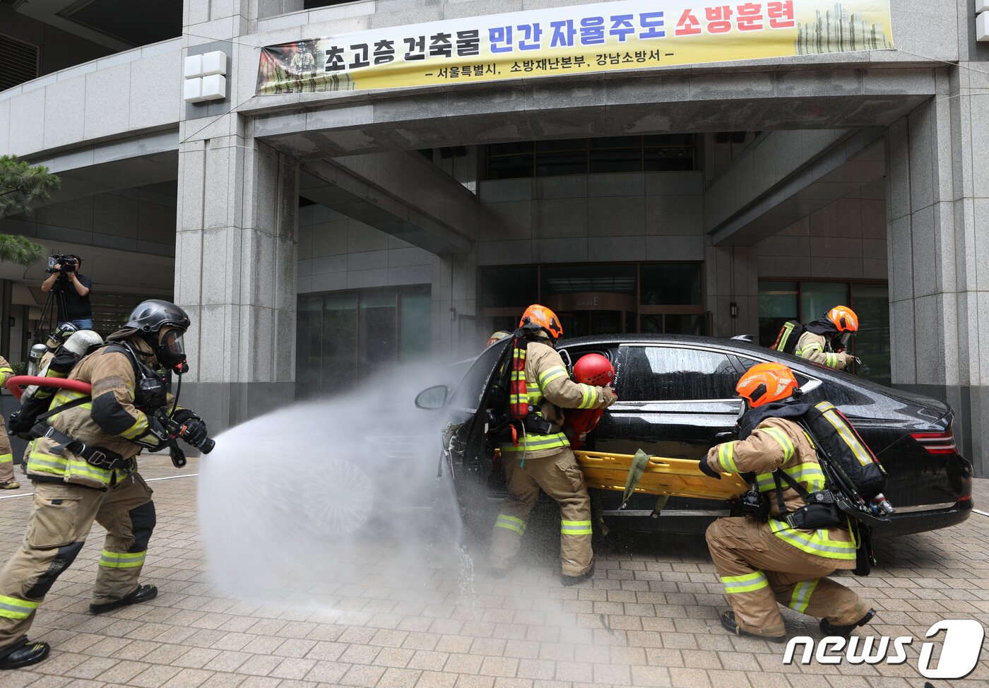 본문 이미지 - 14일 오후 서울 강남구 도곡동의 한 초고층 아파트에서 열린 전기차 화재를 가정한 민·관 합동 소방훈련에서 소방대원들이 전기차 화재를 진압하고 있다.  2023.6.14/뉴스1 ⓒ News1 신웅수 기자
