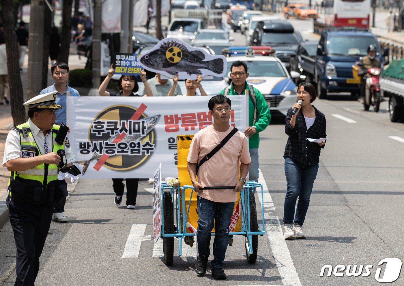 일본 방사성 오염수 해양투기저지서울행동 회원들이 15일 서울 서대문역에서 열린 일본 후쿠시마 오염수 방류 중단 항의 기자회견에서 방사능 드럼통을 운반하는 퍼포먼스를 하며 일본 대사관으로 행진하고 있다. 2023.6.15/뉴스1 ⓒ News1 이재명 기자