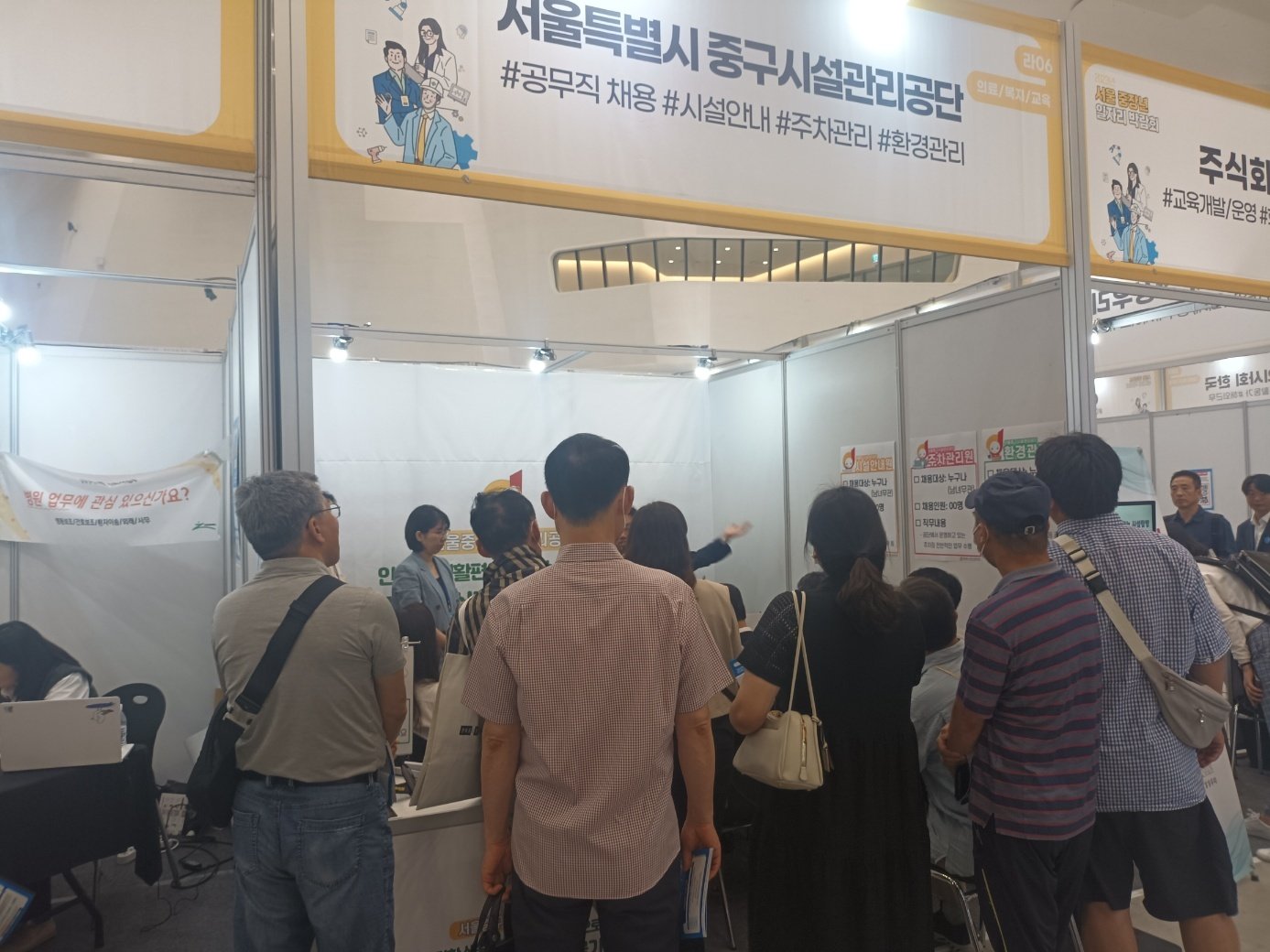 본문 이미지 - &#39;중장년 취업박람회&#39;에서 서울 중구 시설관리공단 부스에 참가자들이 모여 설명을 듣고 있다. 2023.06.15/ ⓒ 뉴스1 박우영 기자