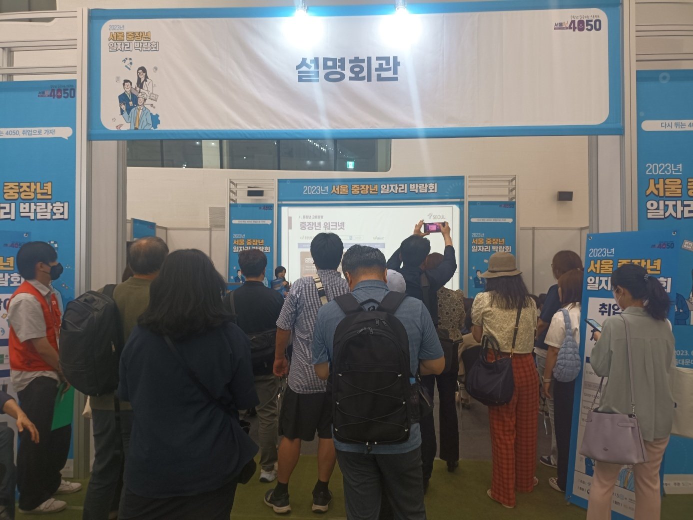 본문 이미지 - &#39;중장년 취업박람회&#39; 전문가 설명회에 구직자들이 모여 설명을 듣고 있다. 2023.06.15/ⓒ 뉴스1 박우영 기자