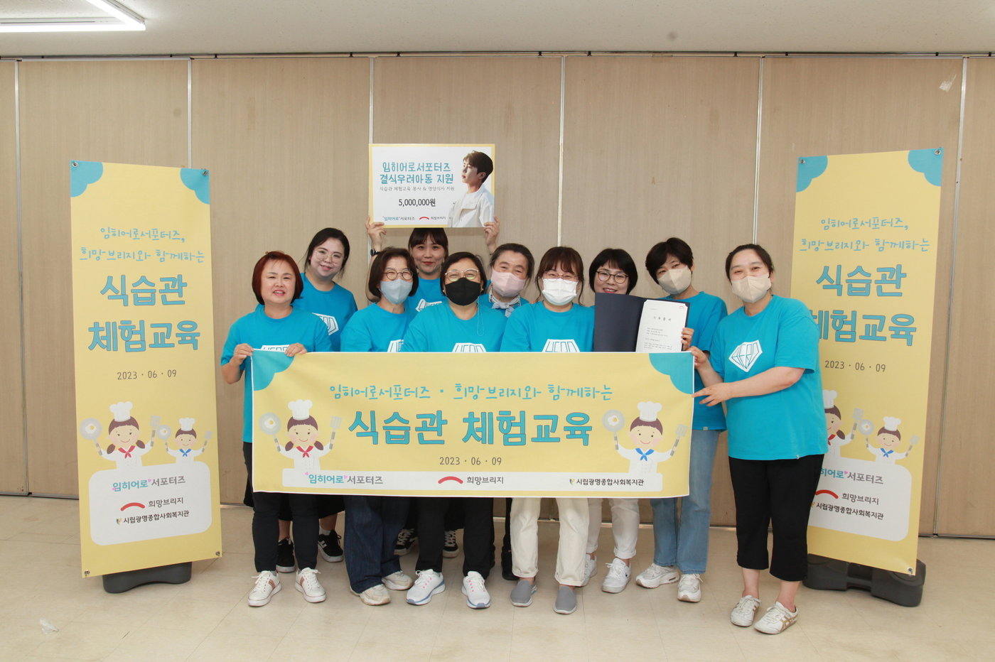 본문 이미지 - 가수 임영웅의 팬클럽 임히어로서포터즈가 임영웅의 생일을 맞아 광명시의 결식 우려 아동들을 위한 식습관 체험교육 봉사활동 후 기념 촬영을 하고 있다. / 사진제공=희망브리지