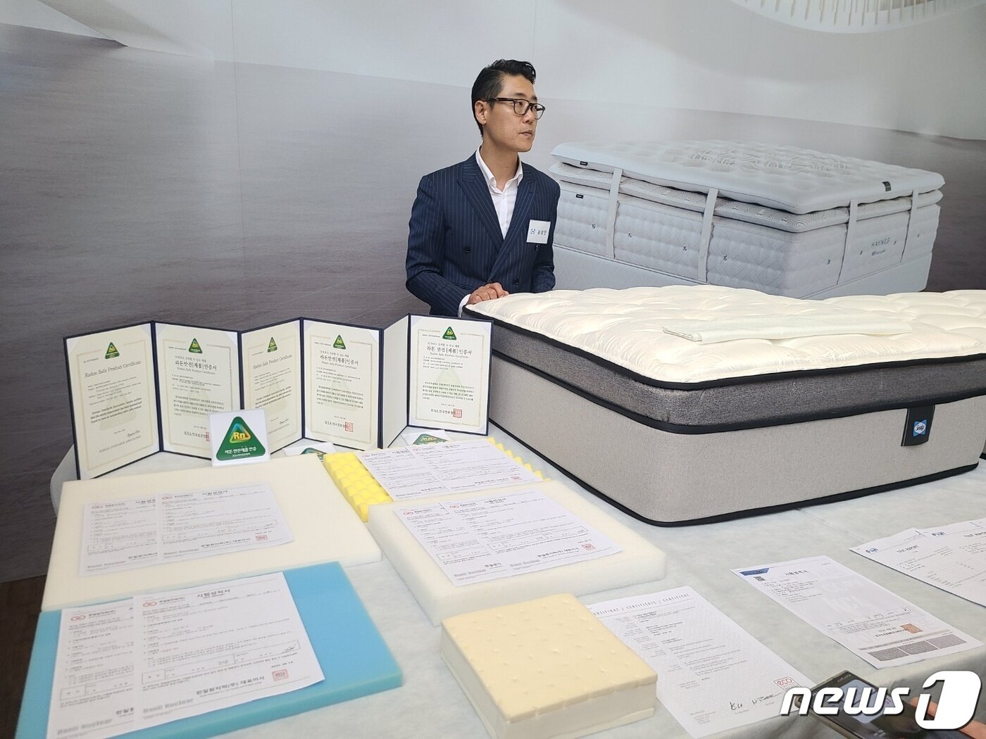 본문 이미지 - 씰리침대 관계자가 국내 공인인증기관으로부터 받은 각종 시험성적서와 인증서 등을 설명하고 있다. ⓒ 뉴스1 김민석 기자 