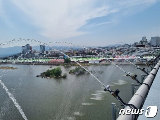 18일 강릉단오제가 열리고 있는 강원 강릉시 남대천 단오행사장 인근 월화교에서 무더위를 식히는 분수가 나오고 있다. 2023.6.18/뉴스1 © News1 윤왕근 기자