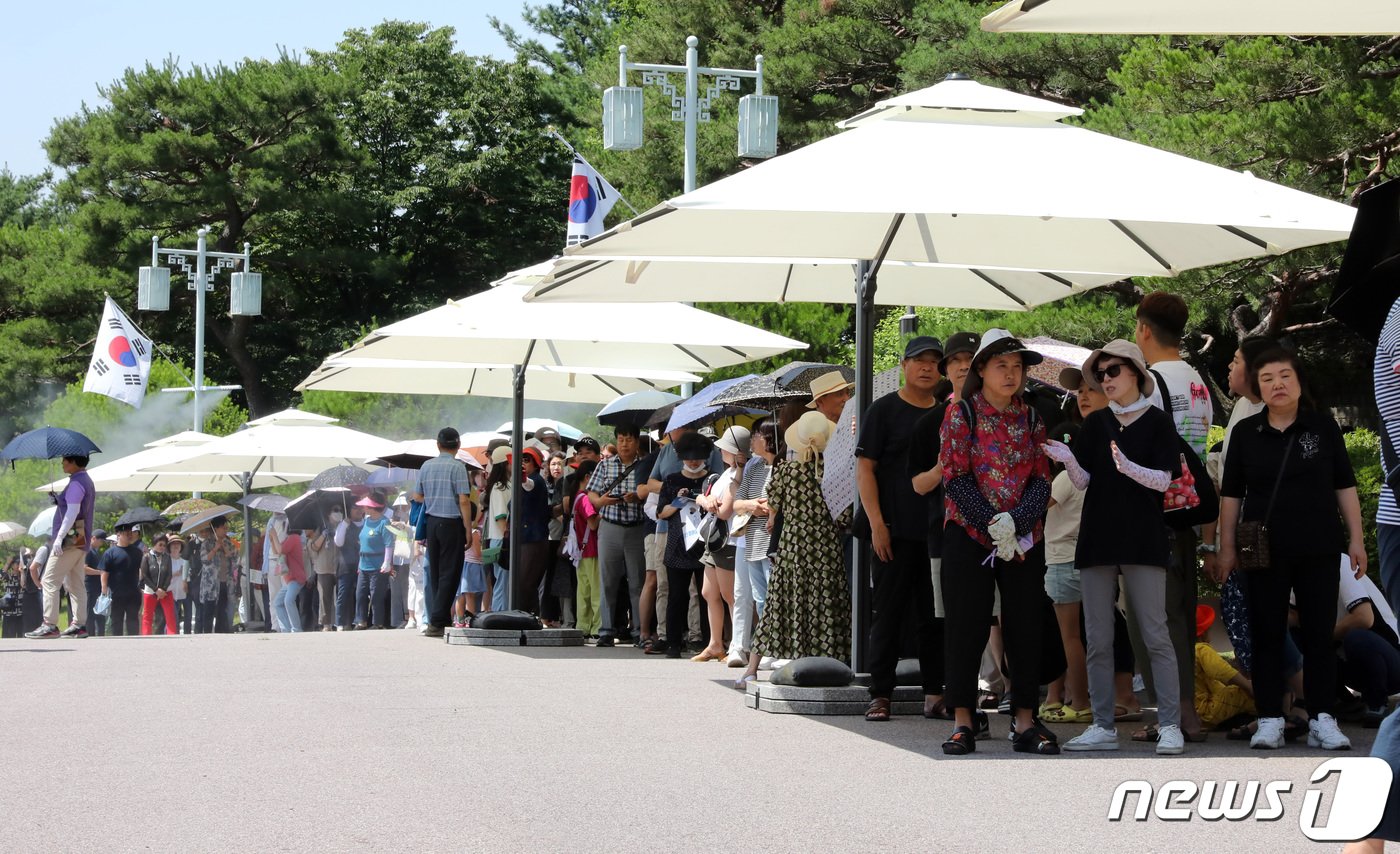 본문 이미지 - 관람객들이 청와대 본관에서 열리고 있는 ‘우리 대통령들의 이야기-여기 대통령들이 있었다’ 전시장에 입장하기 위해 줄을 서고 있다. 대기줄에는 그늘막과 쿨링포그를 설치하고 관람객들에게는 종이선캡을 나눠줘 더위에 대한 관람객 안전확보에 만전을 기하고 있다.