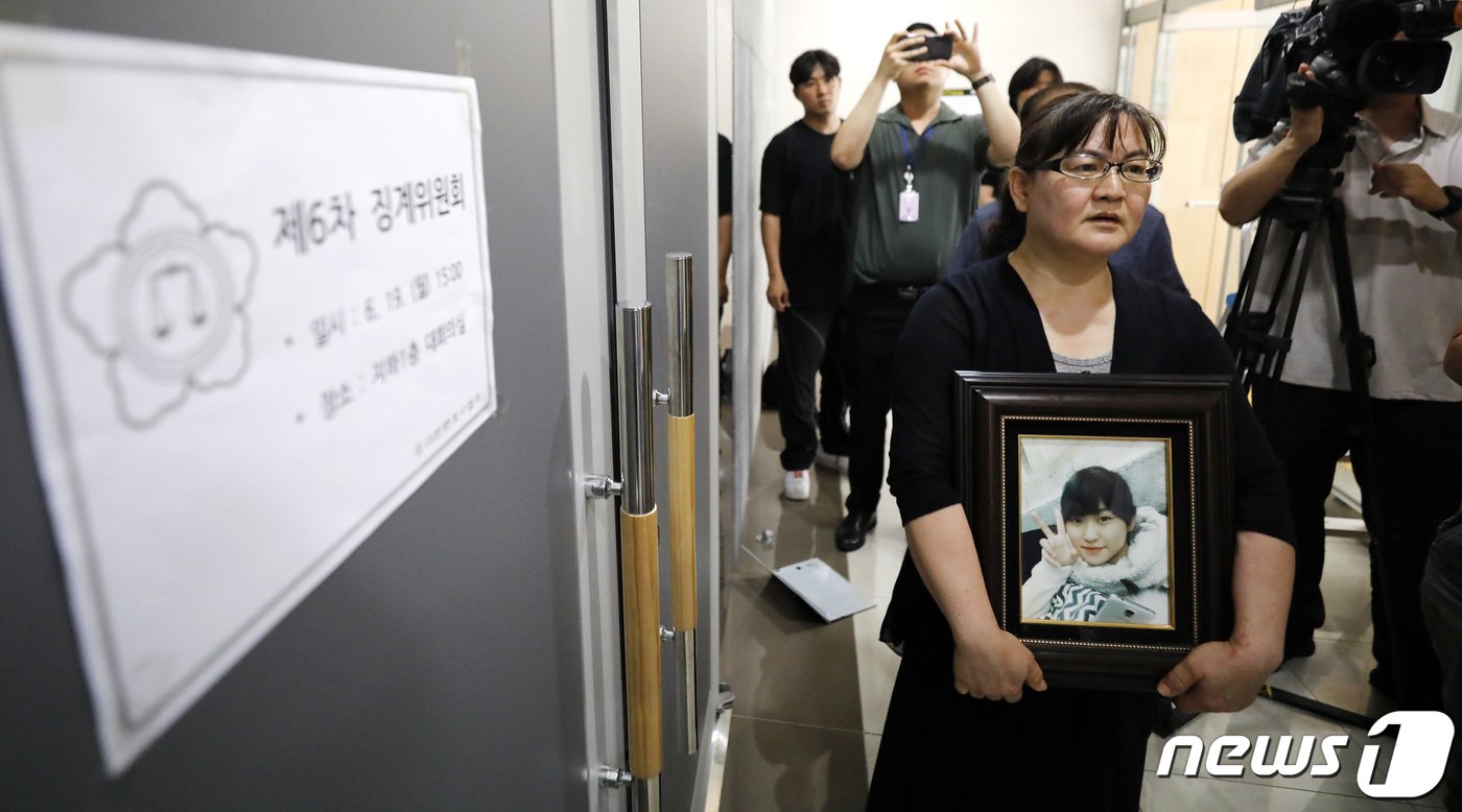 본문 이미지 - 학교폭력 소송에 불출석해 물의를 빚은 권경애 변호사의 징계위원회가 열리는 19일 서울 서초구 대한변호사협회 회관에서 영정 사진을 든 학교폭력 피해자 유족이 권 변호사의 징계 수위 결정을 앞두고 그의 영구 제명을 촉구하며 위원들을 기다리고 있다. 2023.6.19/뉴스1 ⓒ News1 박지혜 기자