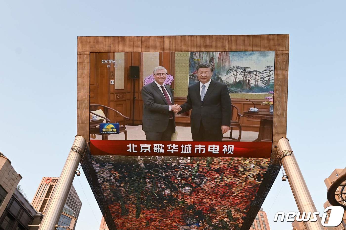 본문 이미지 - 빌 게이츠 마이크로소프트 창업자가 지난 16일 시진핑 주석을 만나고 있는 모습. 중국 CCTV가 전광판을 통해 양자회동을 중계하고 있다. ⓒ AFP=뉴스1 ⓒ News1 박형기 기자