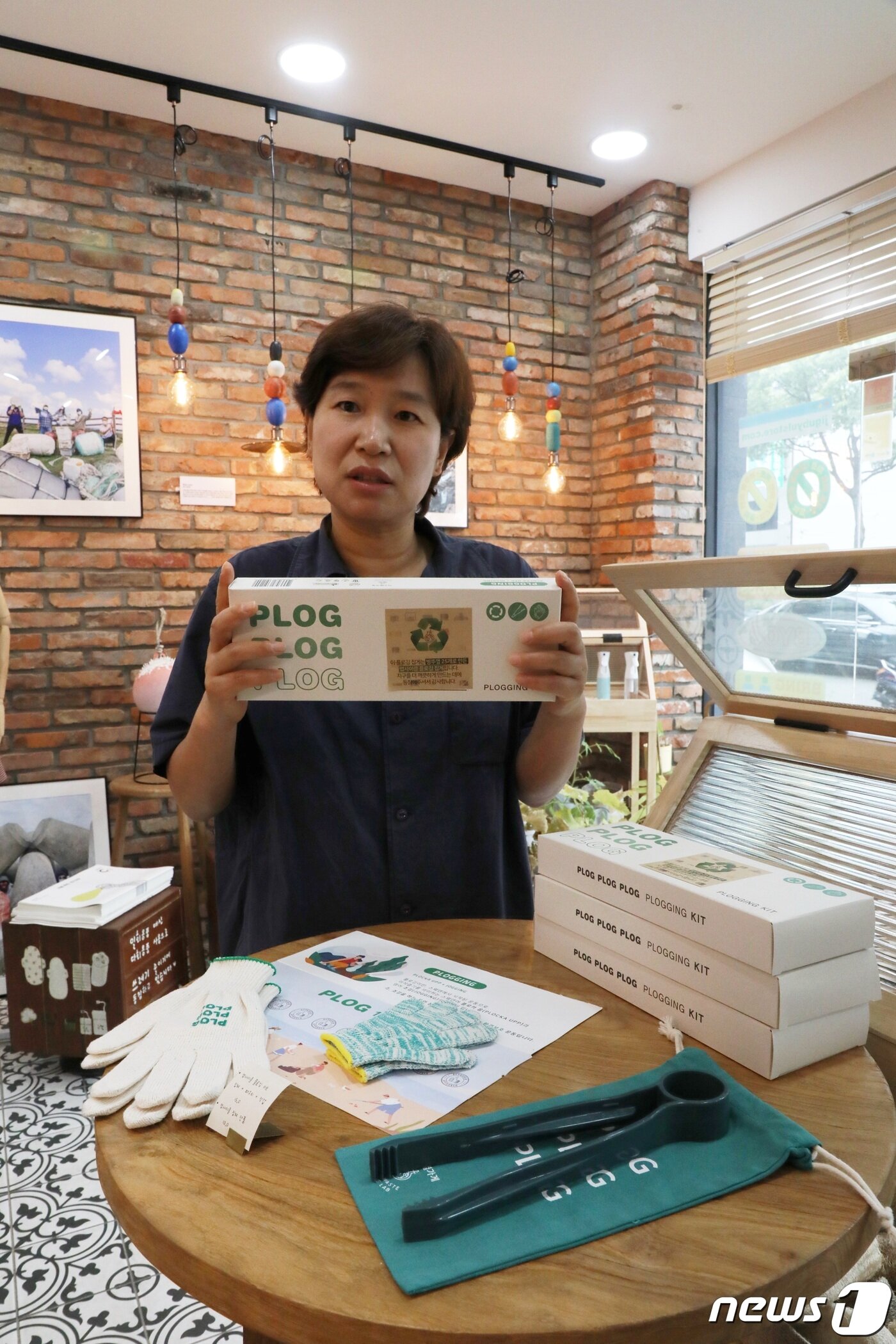 본문 이미지 - 이경미 지구별가게 대표가 플라스틱 병뚜껑으로 만든 플로깅용 집게 세트를 설명하고 있다
