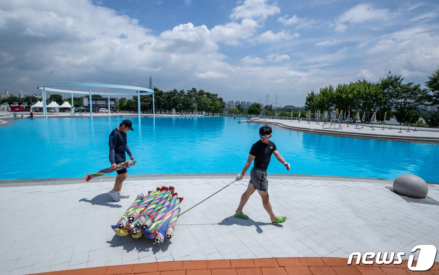 (서울=뉴스1) 이재명 기자 = 22일 오후 서울 광진구 뚝섬 한강공원 수영장에서 관계자들이 개장을 앞두고 막바지 준비를 하고 있다.서울시는 23일부터 8월20일까지 뚝섬, 광나루 …