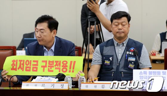 22일 정부세종청사에서 열린 최저임금위원회 제7차 전원회의에서 류기정 경총 전무와 류기섭 한국노총 사무총장이 각각 최저임금 구분적용과 최저임금 인상을 촉구하는 피켓을 보이고 있다. 한편 근로자위원은 이날 2024년도 최저임금 최초요구안으로 1만2210원을 제시했다. 2023.6.22/뉴스1 © News1 장수영 기자