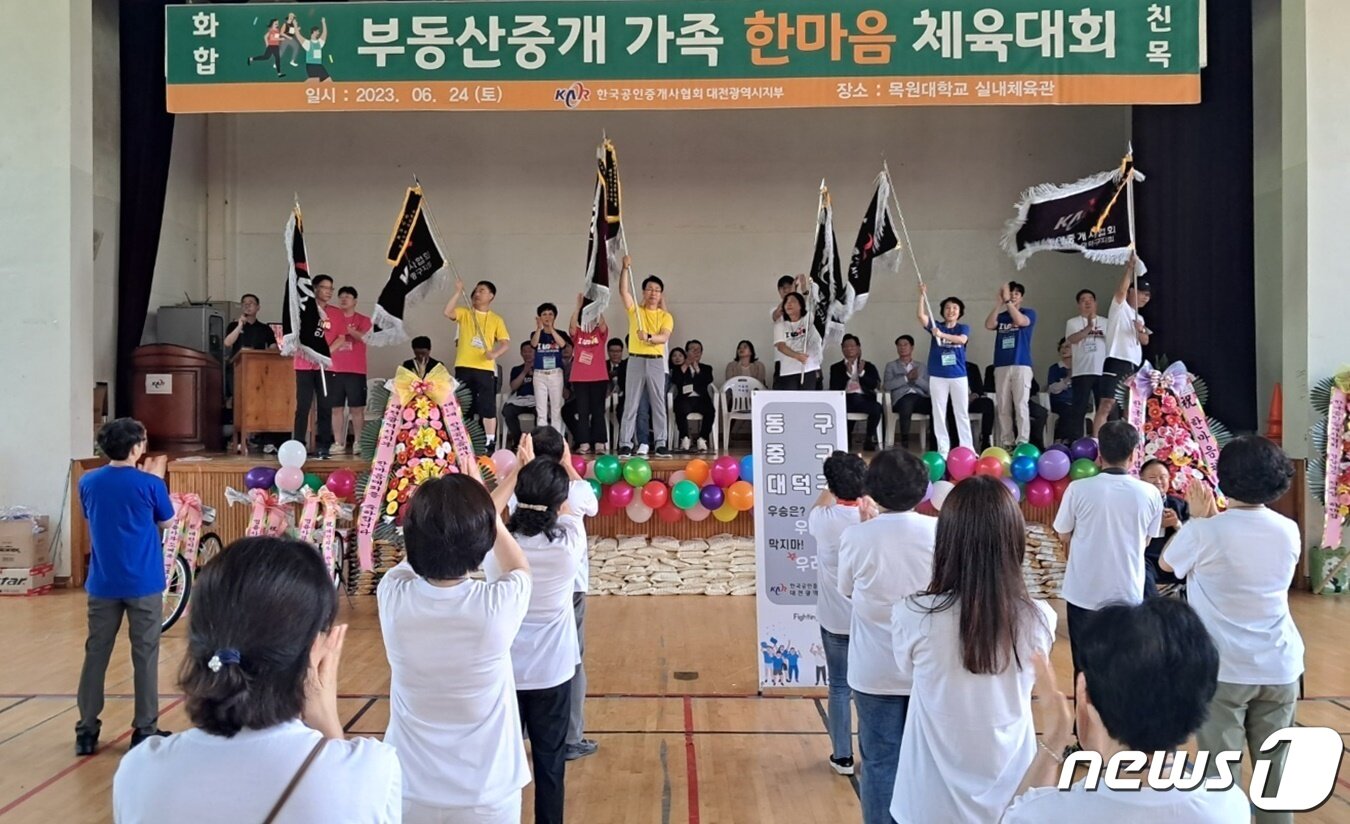 본문 이미지 - 24일 목원대학교 실내체육관에서 열린 한국공인중개사협회 대전지부 한마음 체육대회 개회식에서 임원진이 지부·지회 깃발을 흔들고 있다. /뉴스1 ⓒNews1 최일 기자