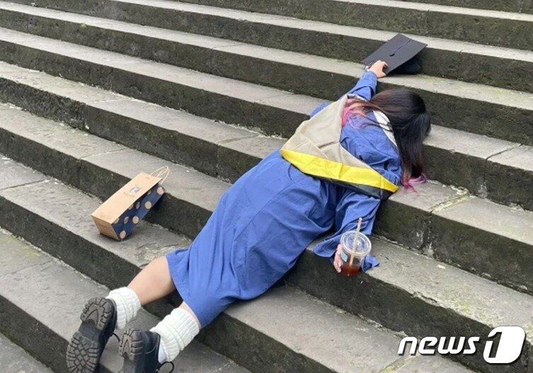 본문 이미지 - 한 졸업생이 계단 위에 대자로 누워 있다.  - 웨이보 갈무리