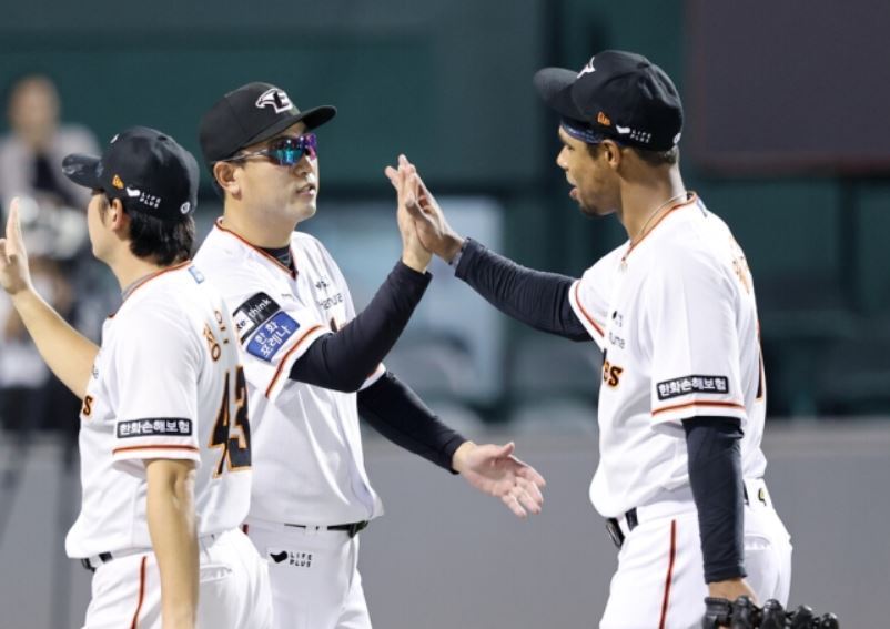 본문 이미지 -  데뷔전을 승리로 마친 후 최원호 감독과 하이파이브를 하는 윌리엄스/(맨 오른쪽) (한화 구단 제공)