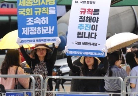 본문 이미지 -  세종시의회 여미전 의원(왼쪽)이 22일 서울 여의도 국회의사당 앞에서 '세종의사당 국회규칙 조속히 개정하라'는 피켓을 들고 시위를 하고 있다. (여미전 의원 제공) / 뉴스1