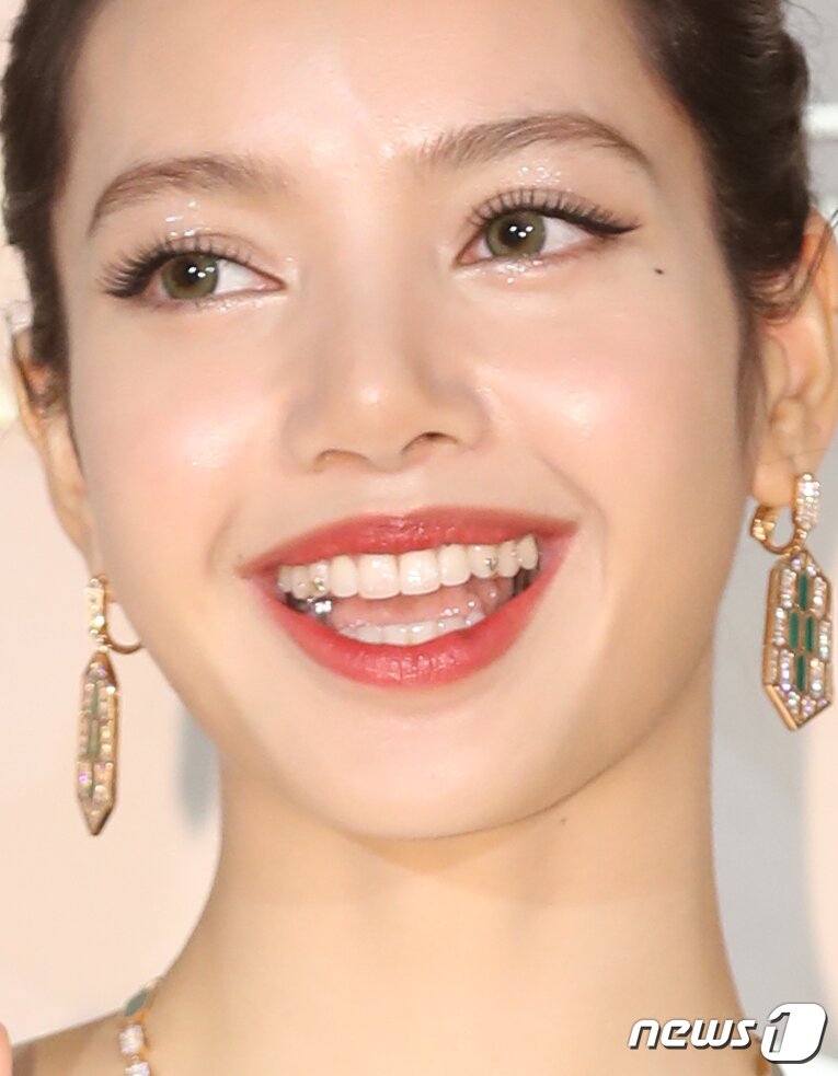 본문 이미지 - 블랙핑크 리사가 28일 오후 서울 종로구 소격동 국제 갤러리에서 진행된 한 명품 브랜드의 컬렉션 75주년 기념 포토월에서 환하게 웃고 있다. 리사의 치아에 은색의 하트와 별 모양의 주얼리가 눈길을 끈다. ⓒ News1 권현진 기자
