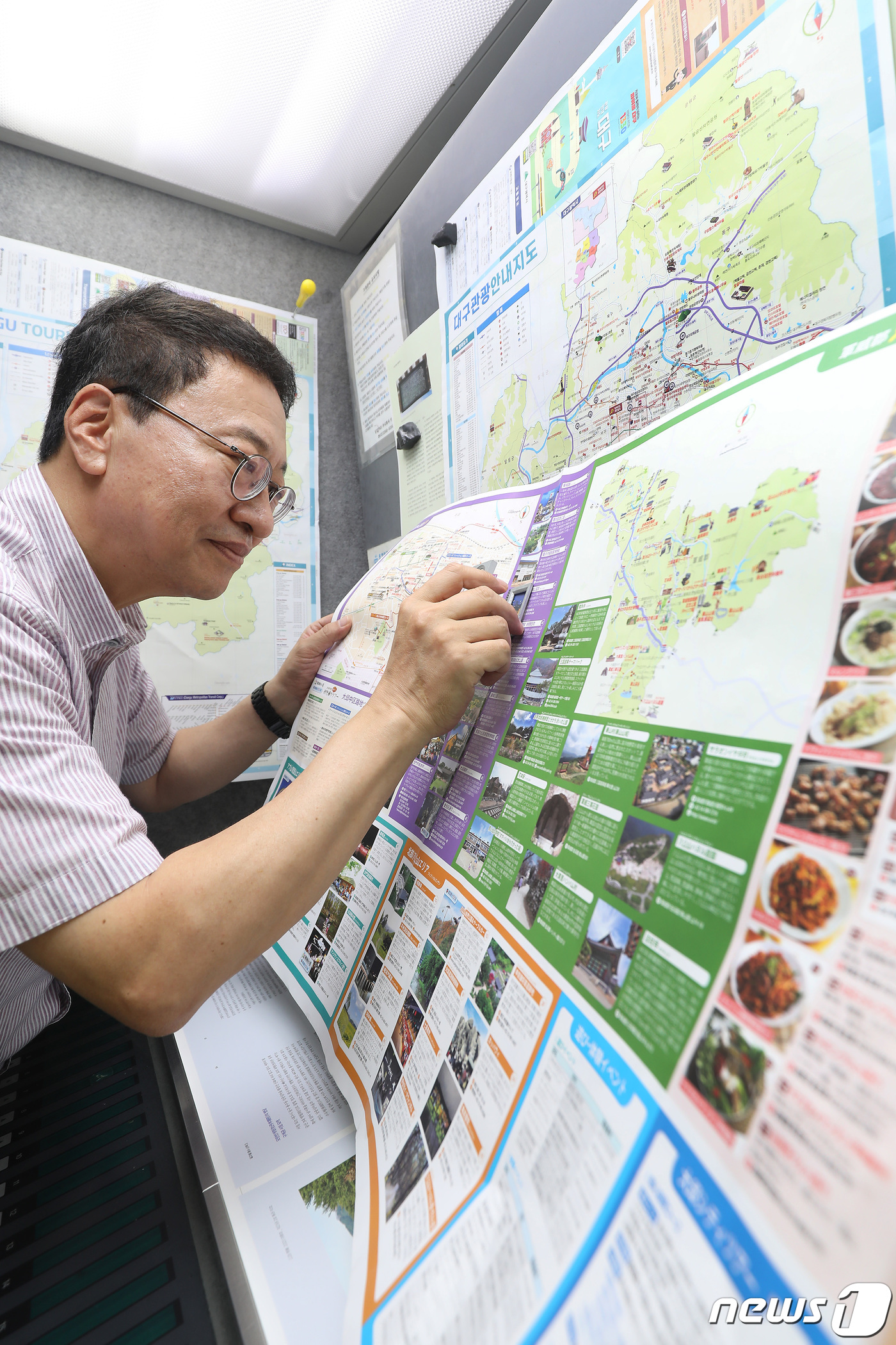(대구=뉴스1) 공정식 기자 = 7월 1일 경북 군위군의 대구광역시 편입을 앞두고 29일 대구 중구 남산동 인쇄업체 아이컴 이진용 대표가 개편된 대구관광 안내지도를 확인하고 있다. …