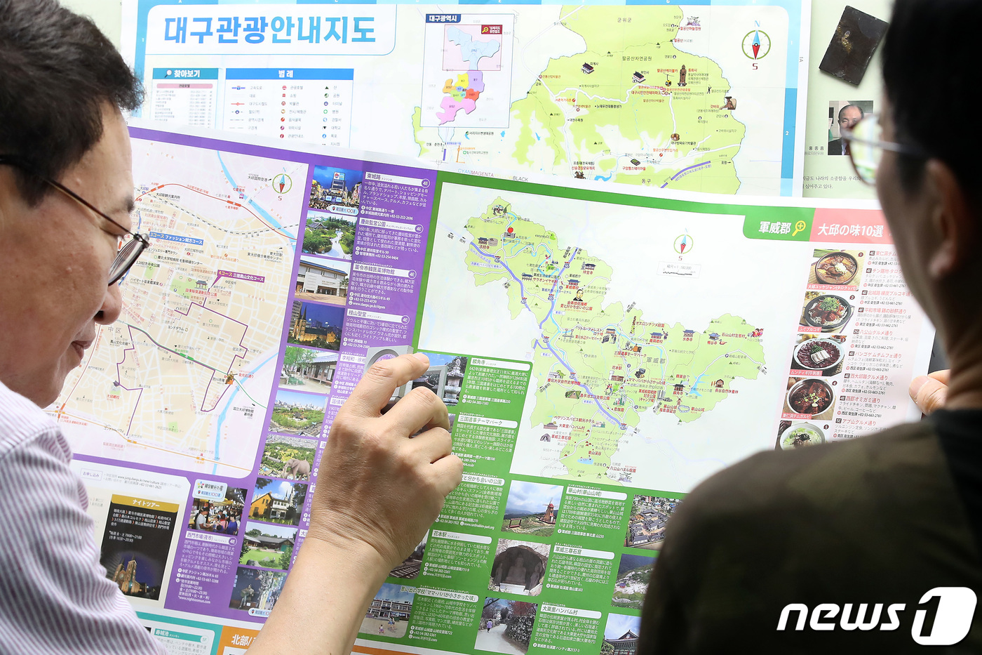 (대구=뉴스1) 공정식 기자 = 7월 1일 경북 군위군의 대구광역시 편입을 앞두고 29일 대구 중구 남산동 인쇄업체 아이컴 이진용 대표가 개편된 대구관광 안내지도를 확인하고 있다. …