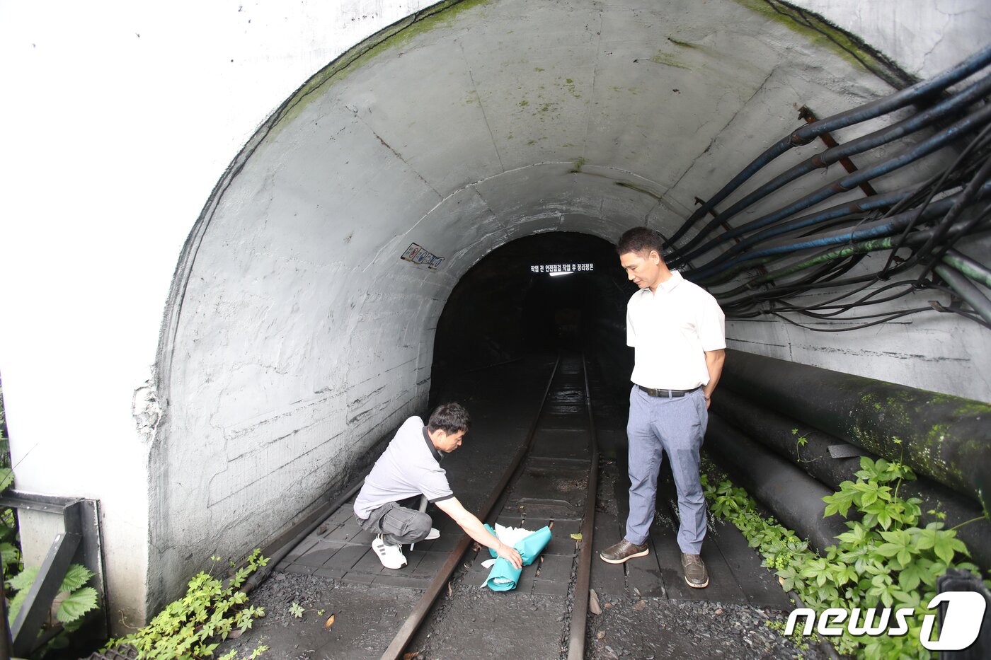 본문 이미지 - 30일 118년 역사의 뒤안길로 사라진 전남 화순광업소에 근로자들이 닫힌 탄광입구에 꽃을 남겨두고 있다. 2023.6.30/뉴스1 ⓒ News1 김태성 기자