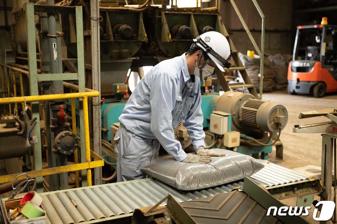 본문 이미지 - 13일 일본 가나가와현 미우라시 미우라 바이오매스 센터에서 직원이 포장을 마친 인분 비료 포대에서 공기를 빼고 있다. 2023.06.13/ ⓒ AFP=뉴스1 ⓒ News1 권진영 기자
