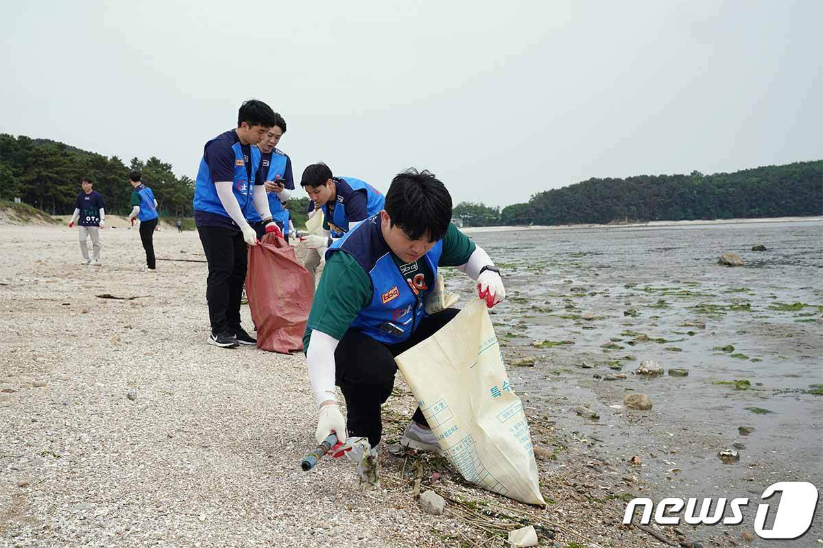 지난달, 바다의 날을 맞아 제너시스BBQ 그룹이 반려해변으로 입양한 인천 용유해변에서 버려진 생활·해양쓰레기를 회수하고 있다.&#40;BBQ 제공&#41;