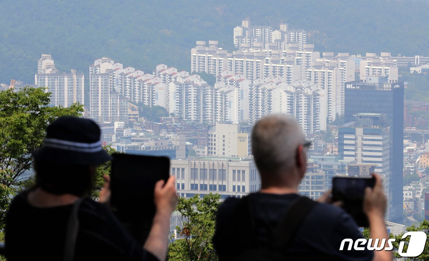 본문 이미지 - 6월4일 서울 중구 남산 전망대를 찾은 시민들이 도심 속 아파트 단지를 바라보고 있다. 전매 제한이 풀린 이후 서울 입주·분양권 거래가 급증한 것으로 나타났다.  2023.6.4/뉴스1 ⓒ News1 김성진 기자
