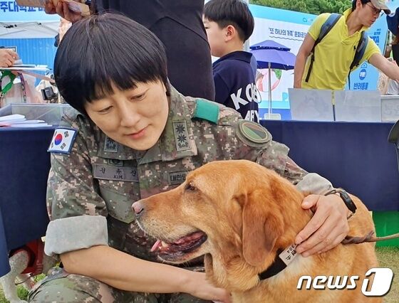 경기도와 경기문화재단은 4일 옛 경기도청 팔달청사에서 '또 하나의 가족, 2023 경기도 펫스타(PETSTA)'를 개최했다. 김유진 중령이 군견에서 은퇴한 개를 쓰다듬고 있다. © 뉴스1 최서윤 기자