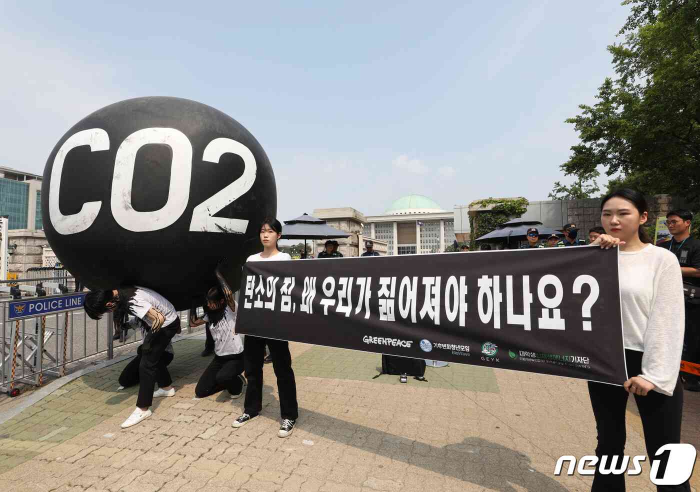 그린피스 회원들이 세계 환경의 날인 5일 서울 여의도 국회 앞에서 기후위기 대응을 촉구하는 '탄소(CO2)의 짐' 퍼포먼스를 하고 있다. 2023.6.5/뉴스1 © News1 신웅수 기자