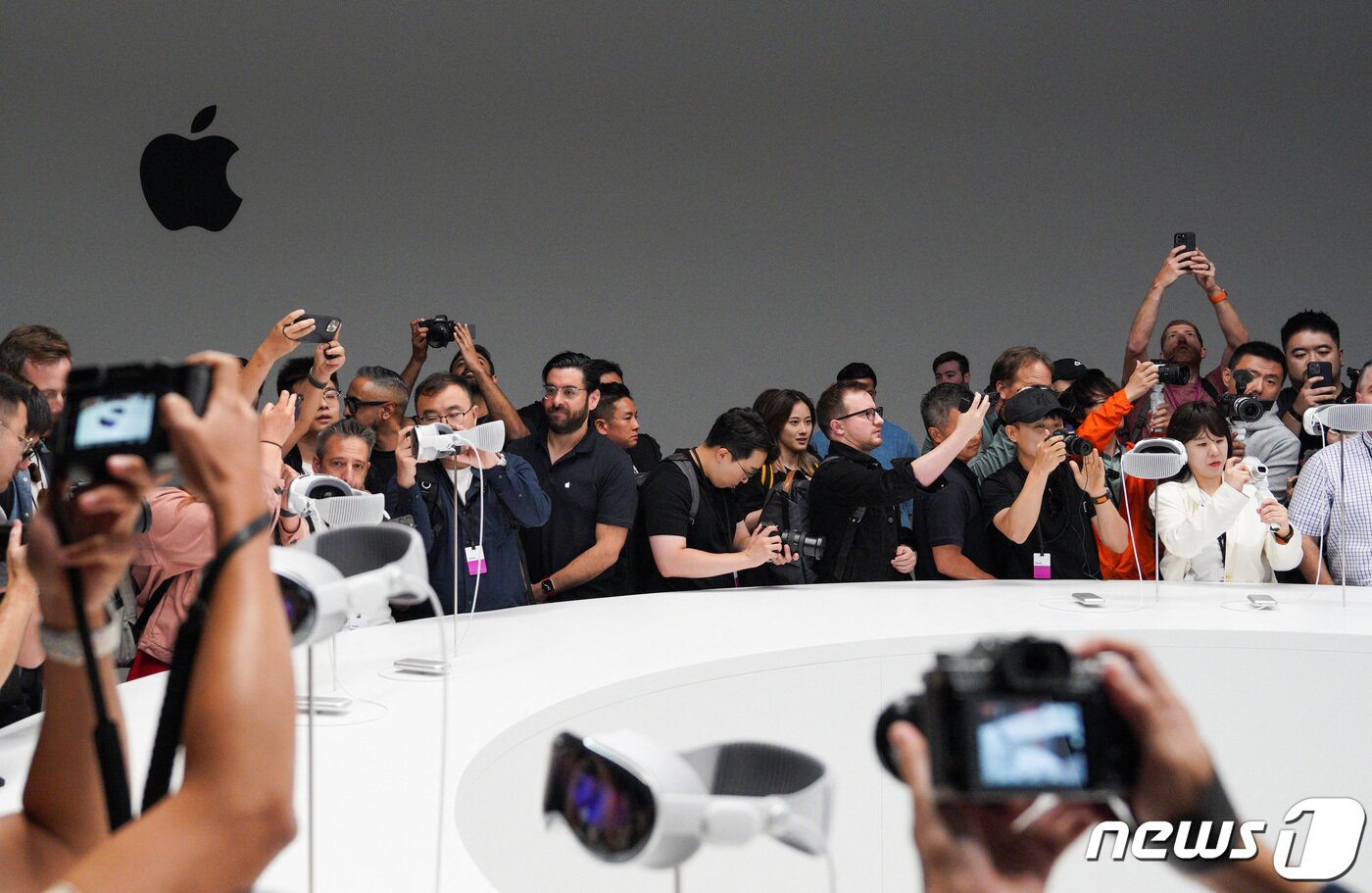 본문 이미지 - 비전 프로가 공개되자 애플 마니아들이 카메라에 이를 담으며 열광하고 있다. ⓒ 로이터=뉴스1 ⓒ News1 박형기 기자