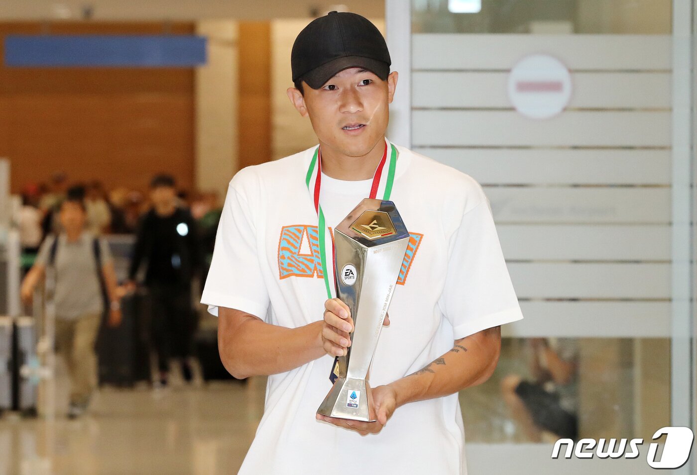 본문 이미지 - 이탈리아 프로축구 세리에A 나폴리의 수비수 김민재가 6일 기초군사훈련 입소를 위해 인천국제공항을 통해 귀국하며 세리에A 최우수 수비수상 트로피를 들어 보이고 있다. 나폴리를 33년만에 리그우승으로 이끈 김민재는 아시아 선수 최초로 이탈리아 세리에A 최우수 수비수상을 수상했다. 2023.6.6/뉴스1 ⓒ News1 박세연 기자