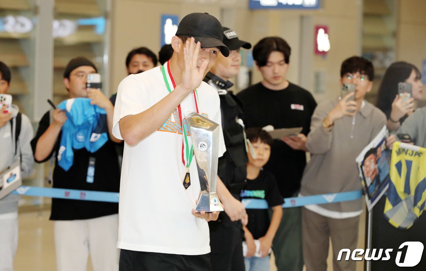 본문 이미지 - 이탈리아 프로축구 세리에A 나폴리의 수비수 김민재가 6일 기초군사훈련 입소를 위해 인천국제공항을 통해 귀국하며 세리에A 최우수 수비수상 트로피를 들어 보이고 있다. 나폴리를 33년만에 리그우승으로 이끈 김민재는 아시아 선수 최초로 이탈리아 세리에A 최우수 수비수상을 수상했다. 2023.6.6/뉴스1 ⓒ News1 박세연 기자