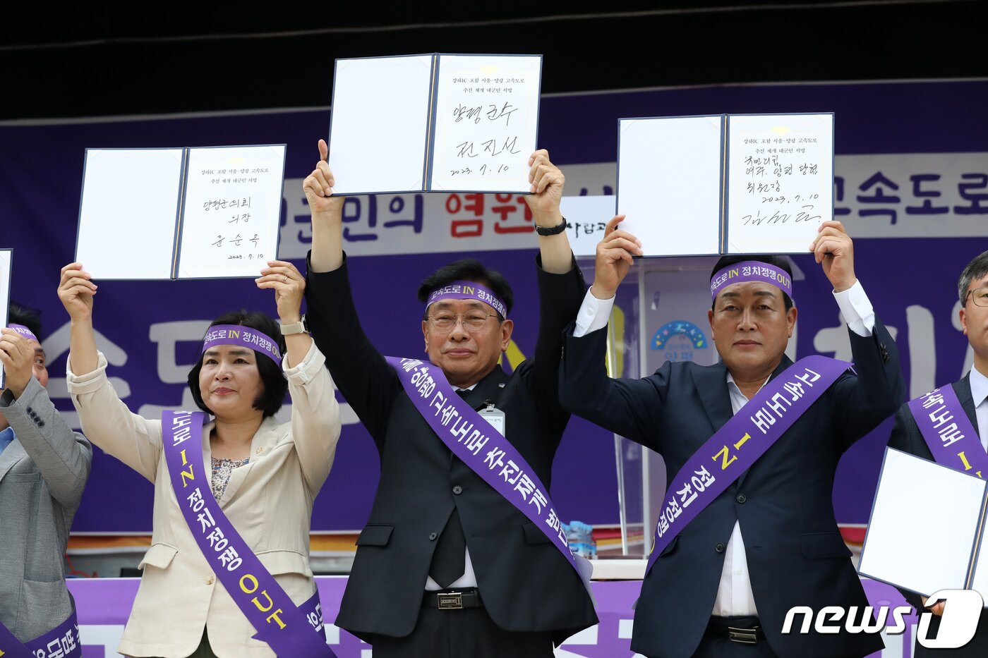 본문 이미지 - 전진선 양평군수가 경기 양평군청 앞에서 열린 &#39;서울-양평 고속도로 재개 범군민 대책위원회 출정식&#39;에 참석해 고속도로 사업 재개를 촉구하는 대군민 서명을 한 뒤 들어보이고 있다.2023.7.10/뉴스1 