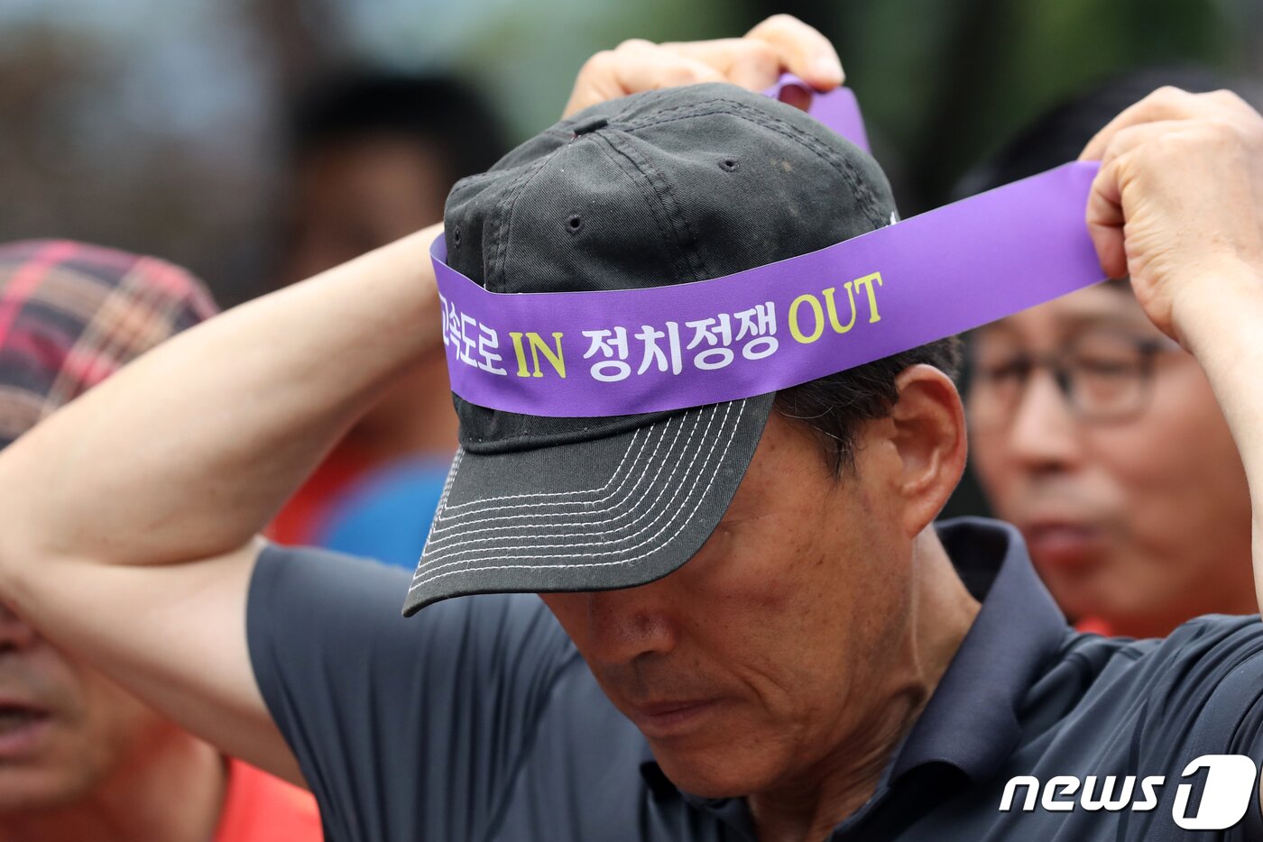 본문 이미지 - 2023년 7월 10일 오전 경기도 양평군청 앞에서 열린 &#39;서울-양평 고속도로 재개 범군민 대책위원회 출정식&#39;에 한 지역주민이 사업 재개를 촉구하는 머리띠를 두르고 있다.  2023.7.10/뉴스1 ⓒ News1 이승배 기자 