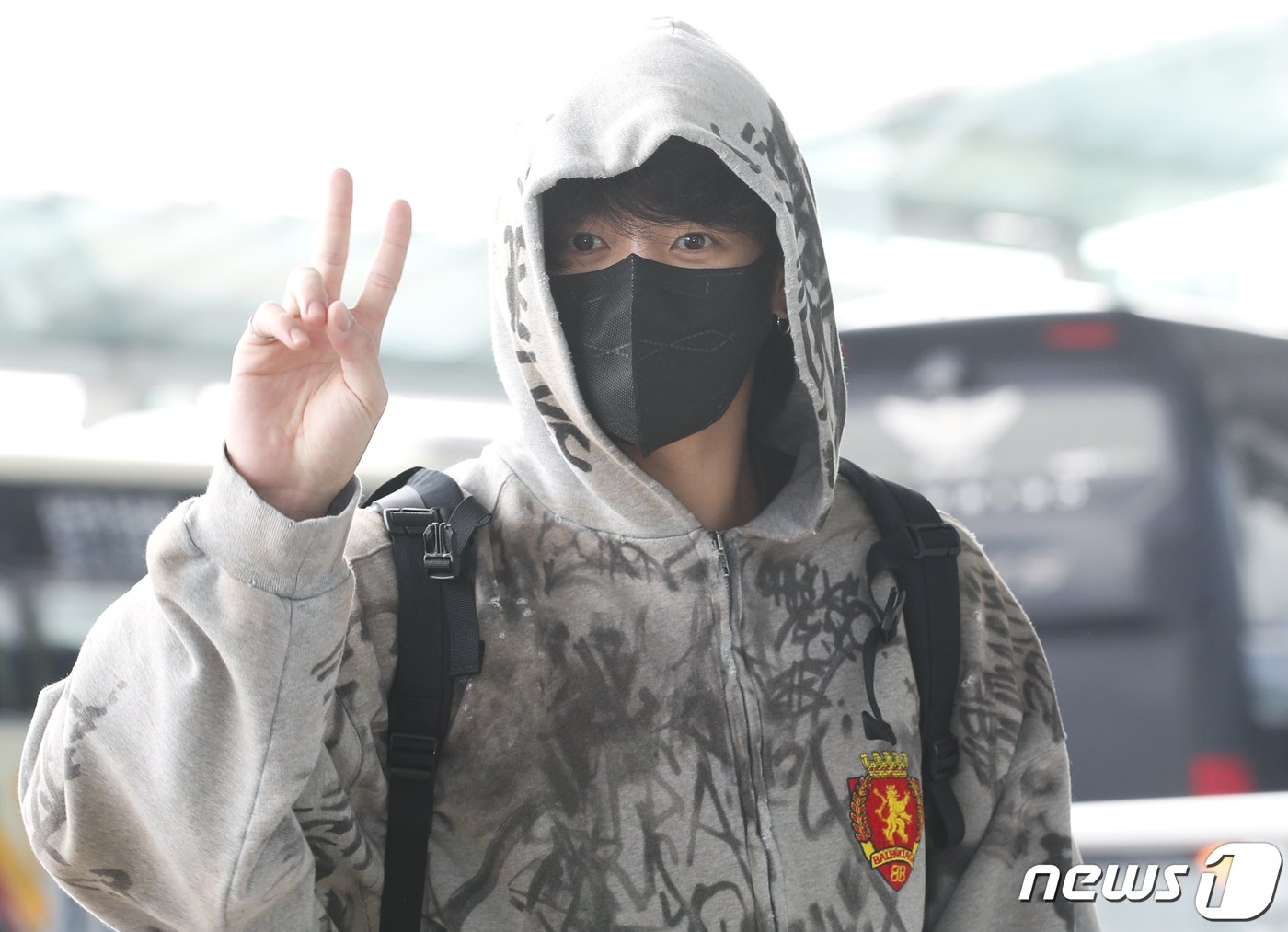 본문 이미지 - 방탄소년단(BTS) 정국이 해외 일정을 위해 12일 인천국제공항에 도착해 미국 뉴욕으로 출국하기 전 브이를 그리고 있다. ⓒ News1 권현진 기자