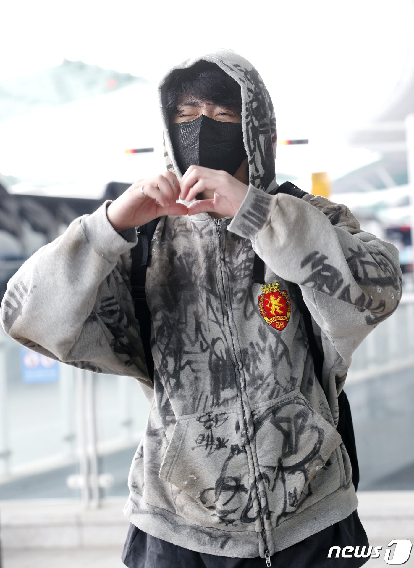 본문 이미지 - 방탄소년단(BTS) 정국이 해외 일정을 위해 12일 인천공항에 도착해 미국 뉴욕으로 출국하기 전 비몽사몽 하트로 인사를 전하고 있다. ⓒ News1 권현진 기자