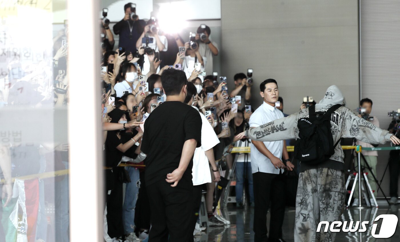 본문 이미지 - 방탄소년단(BTS) 정국이 해외 일정을 위해 12일 인천국제공항을 통해 미국 뉴욕으로 출국하며 환호하는 팬에게 비행기 포즈를 취하며 인사를 하고 있다. ⓒ News1 권현진 기자