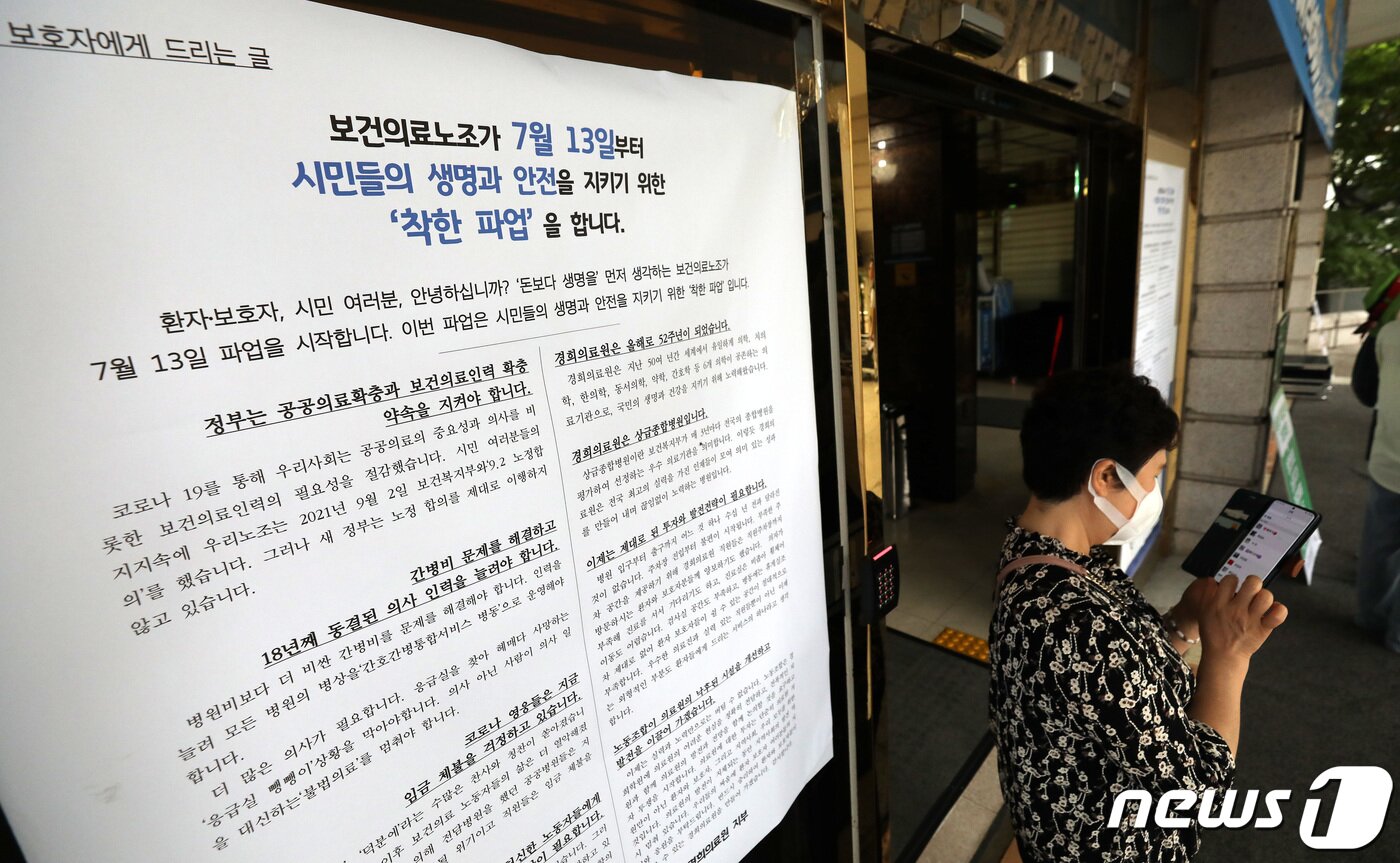 본문 이미지 - 13일 서울 동대문구 경희대병원 입구에 붙은 민주노총 산하 보건의료노조의 처우개선, 공공의료 확충 등을 요구하는 총파업 돌입을 알리는 안내문 앞으로 환자 및 보호자들이 지나가고 있다. 2023.7.13/뉴스1 ⓒ News1 박지혜 기자