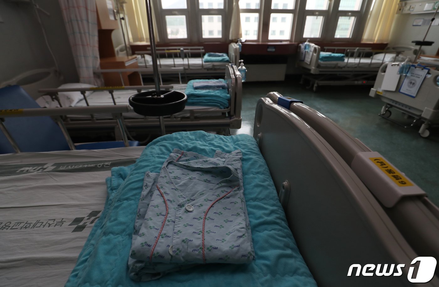 본문 이미지 - 보건의료노조가 처우개선, 공공의료 확충 등을 요구하며 총파업에 돌입한 13일 오후 부산 서구 부산대병원 일반병동 병실이 텅 비어 있는 가운데 침상에 환자복이 놓여 있다. 부산대병원은 보건의료노조 총파업에 대비해 지난 11일부터 중환자, 전원 불가 환자를 제외한 대부분의 환자들을 전원·퇴원 조치했다. 2023.7.13/뉴스1 ⓒ News1 윤일지 기자