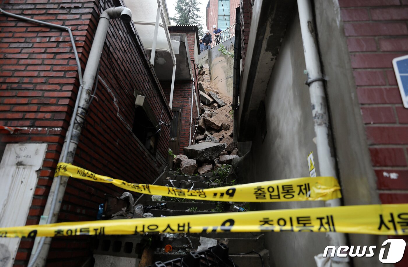 본문 이미지 - 14일 서울 서대문구 연희동에서 구청 관계자들이 지난밤 폭우로 무너진 축대를 복구하고 있다. 이 사고로 인근 20가구 46명이 심야에 긴급 대피했다. 2023.7.14/뉴스1 ⓒ News1 박지혜 기자