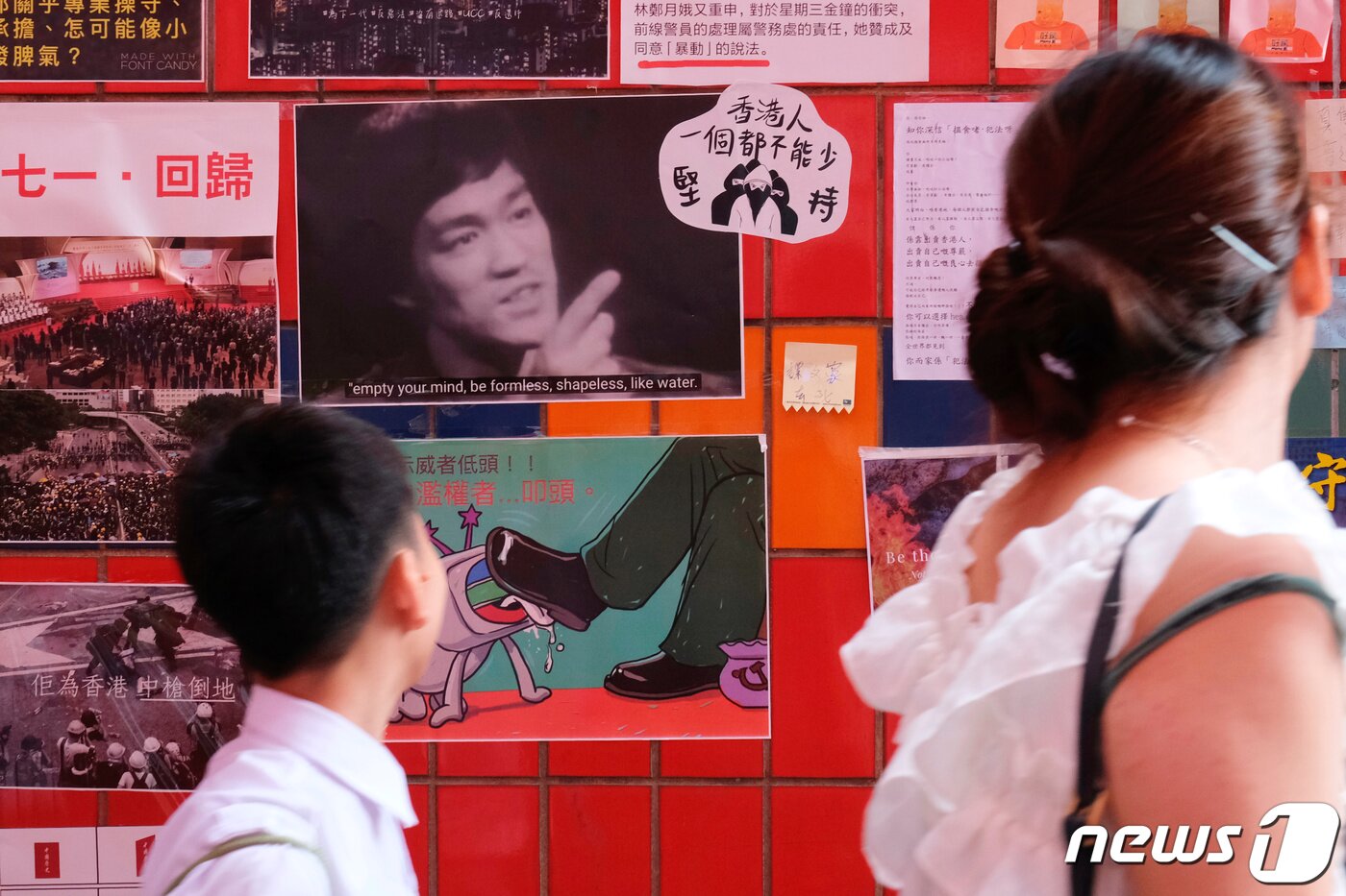 본문 이미지 - 범죄인 인도법(송환법)으로 촉발된 홍콩의 대규모 시위가 이어지던 2019년 7월 홍콩의 민주화 지지하는 포스터들이 붙은 '레넌벽'에 이소룡의 사진이 걸려있다. 2019.07.16/ ⓒ 로이터=뉴스1 ⓒ News1 박재하 기자