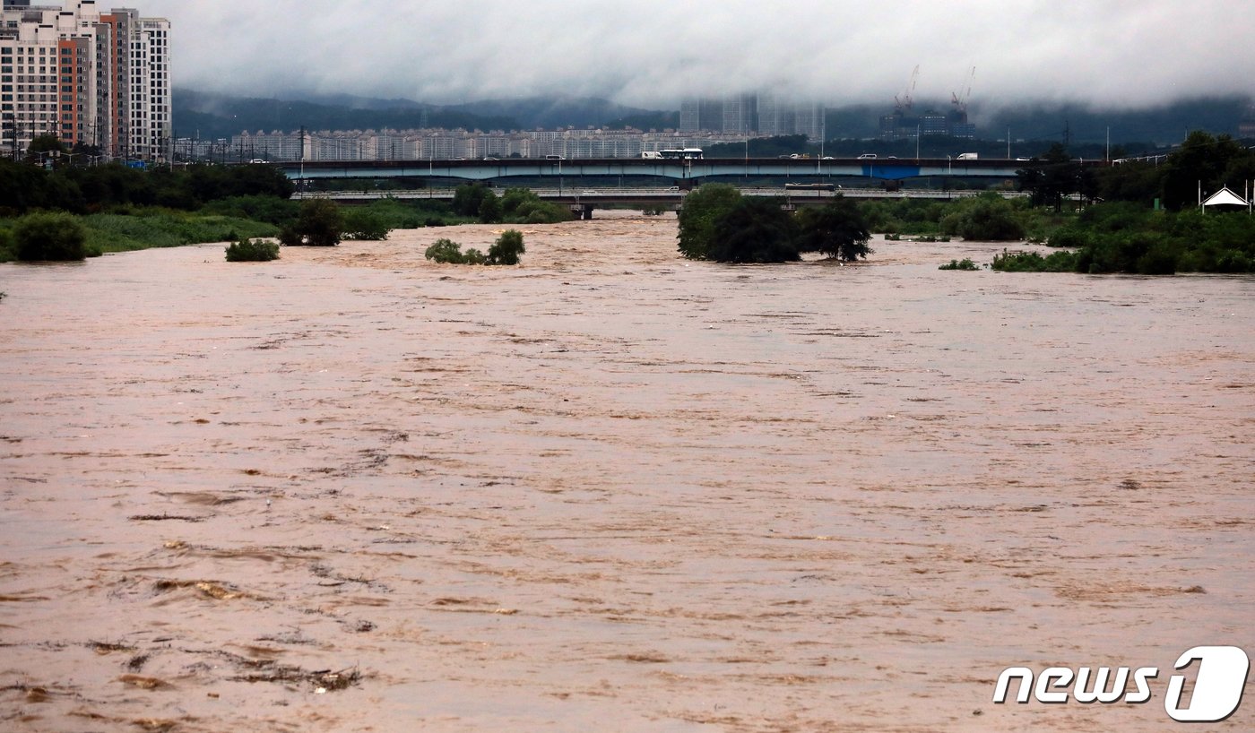 본문 이미지 - 14일 오후 홍수 주의보가 내려진 충북 청주시 무심천 흥덕교 인근 산책로가 물에 잠겨 있다.  2023.7.14/뉴스1 ⓒ News1 김용빈 기자