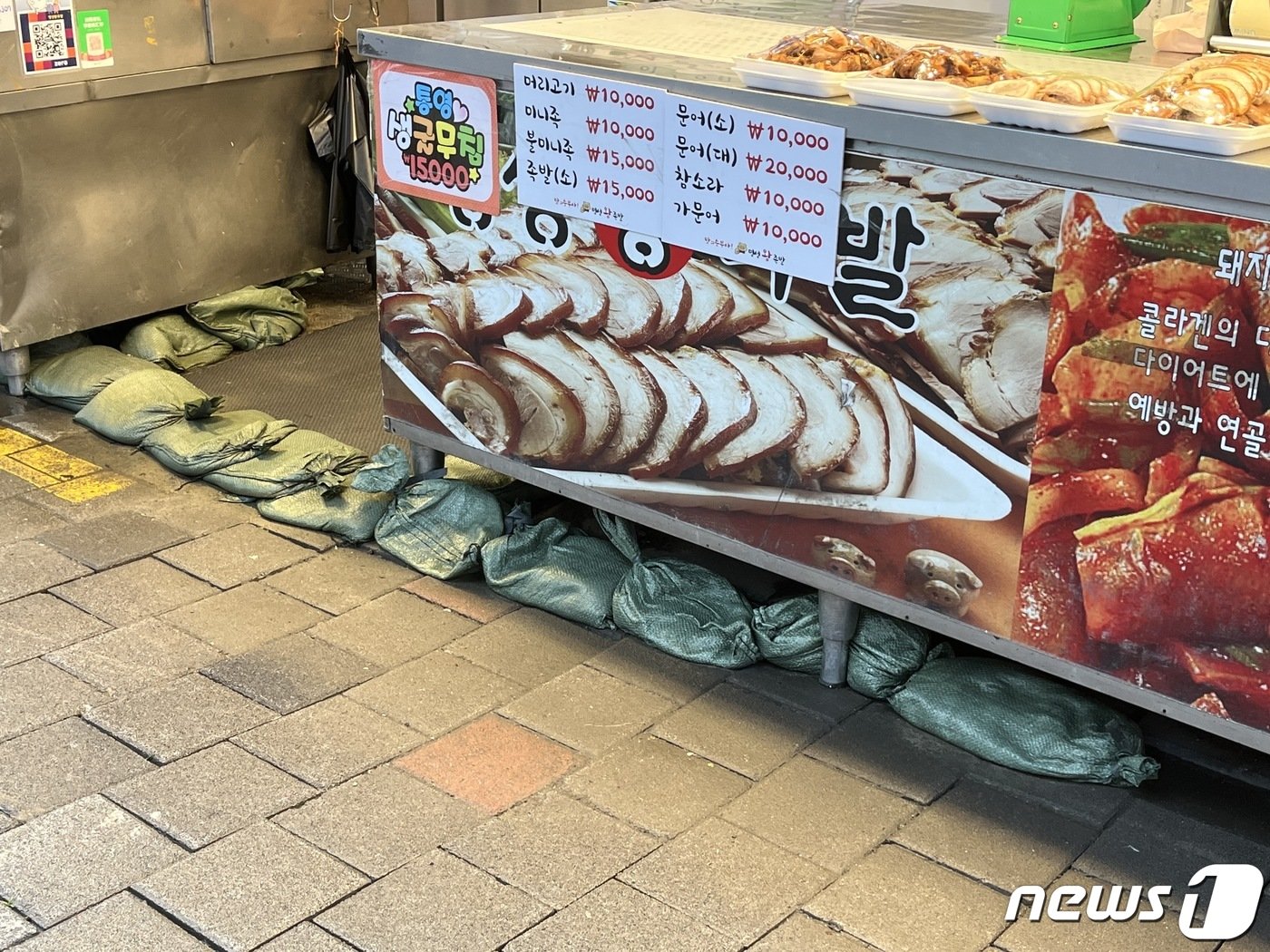 본문 이미지 - 한 남성사계시장 상인이 비를 막기 위해 점포 앞을 모래주머니로 막아뒀다. ⓒ News1 김형준 기자