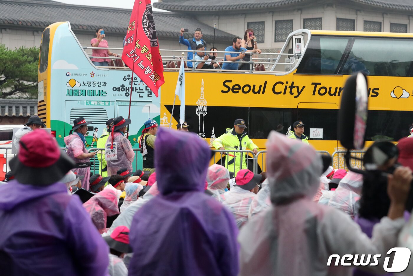 본문 이미지 - 15일 서울 종로구 사직로 일대에서 이층버스에 탑승한 외국인 관광객들이 '윤석열 정권 퇴진 7.15 범국민대회'에서 참가자들을 바라보고 있다. 2023.7.15/뉴스1